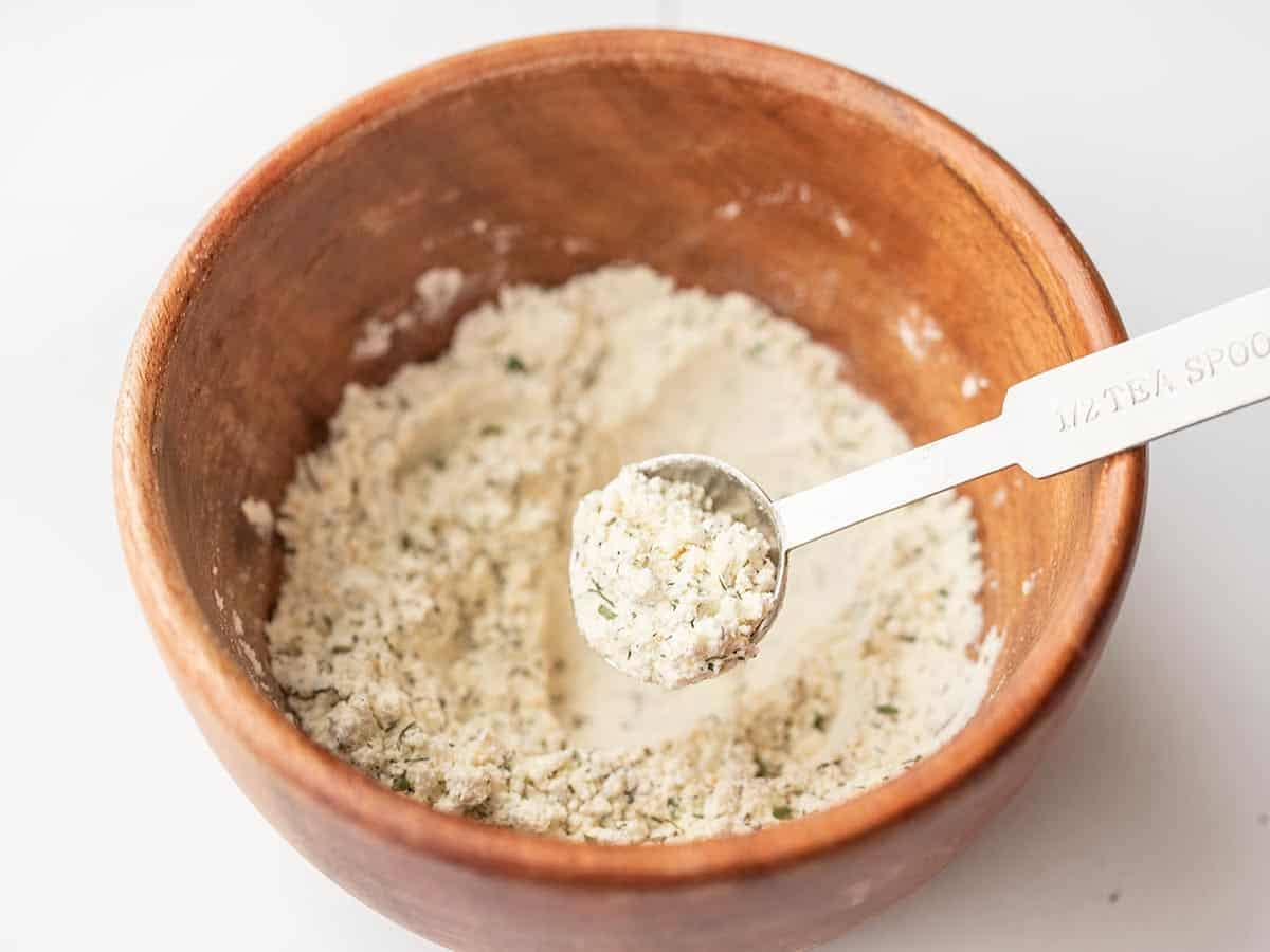close up of mixed ranch seasoning in the bowl with a measuring spoon