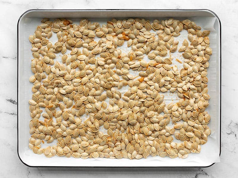 Raw pumpkin seeds on a baking sheet