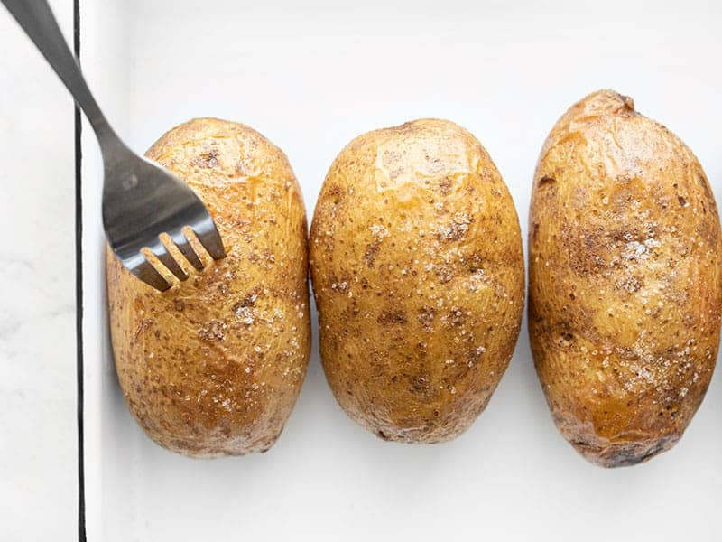 A fork piercing into a baked potato