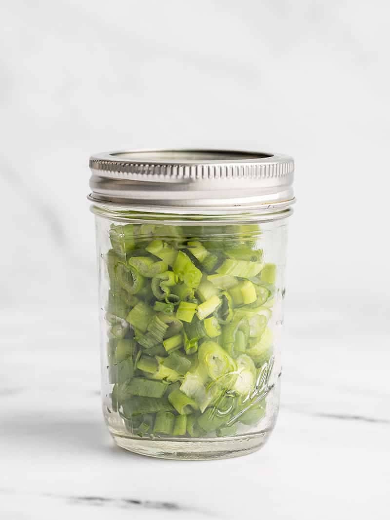 Fresh sliced green onions in a jar