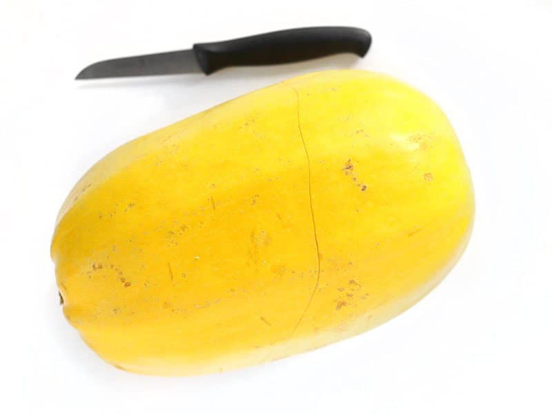 Large spaghetti squash with a paring knife on the side