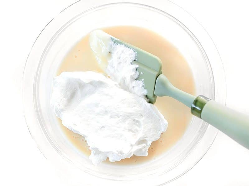 Whipped Cream beginning to be folded into sweetened condensed milk
