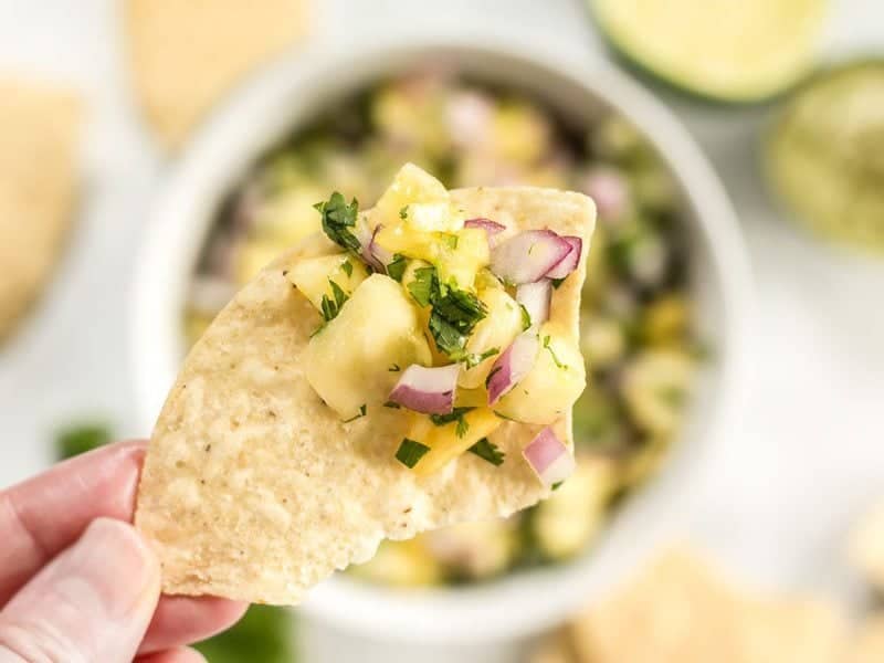 Close up of easy pineapple salsa on a tortilla chip