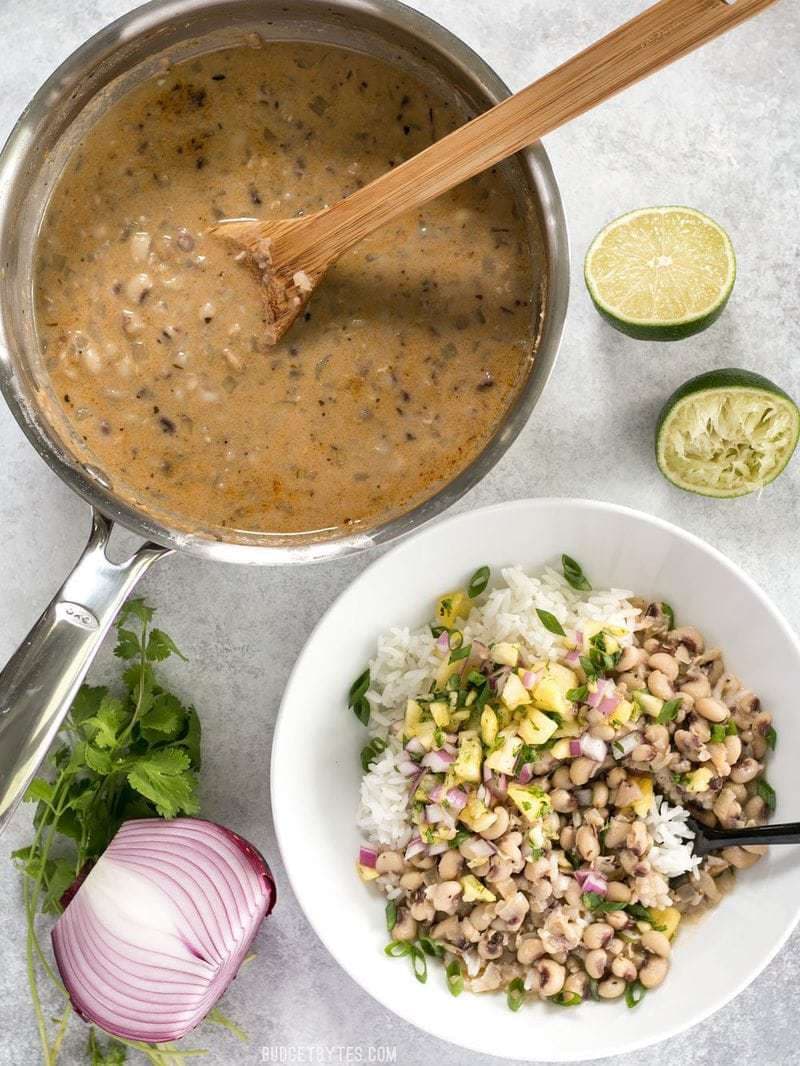 A pot of Coconut Jerk Peas next to a bowl of peas with rice and salsa