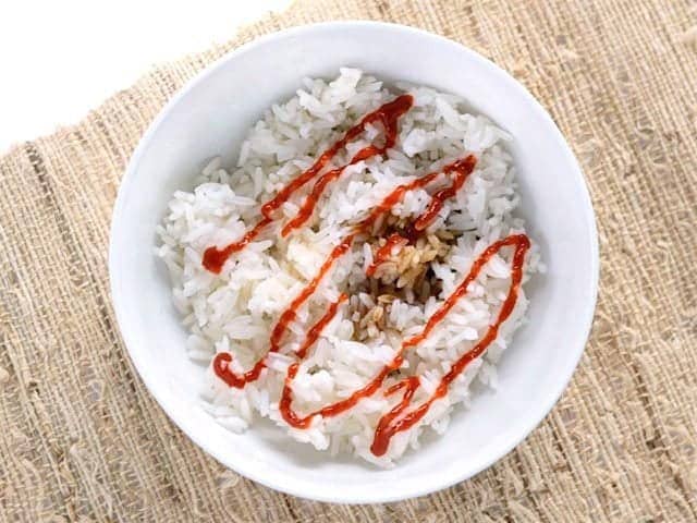 Soy sauce and sriracha added to cooked rice