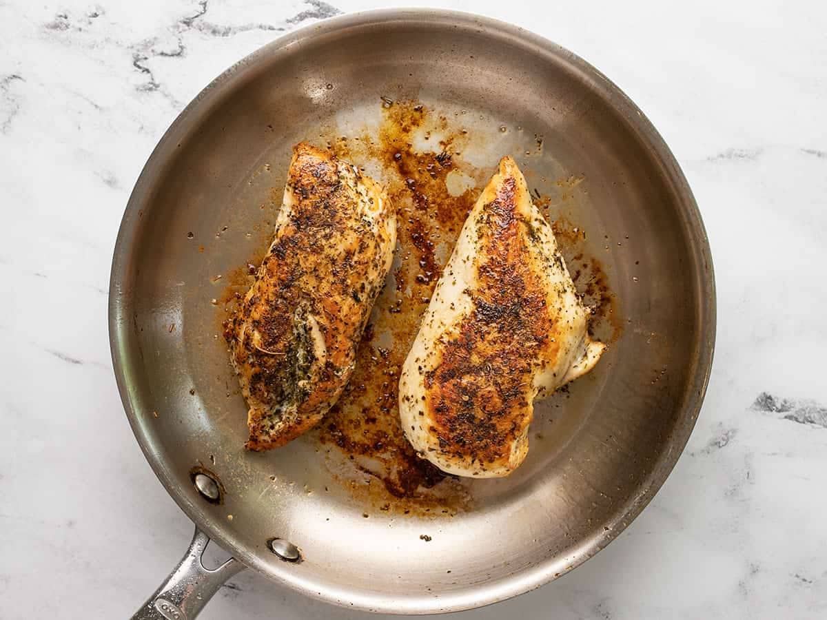 Seared chicken in the skillet.