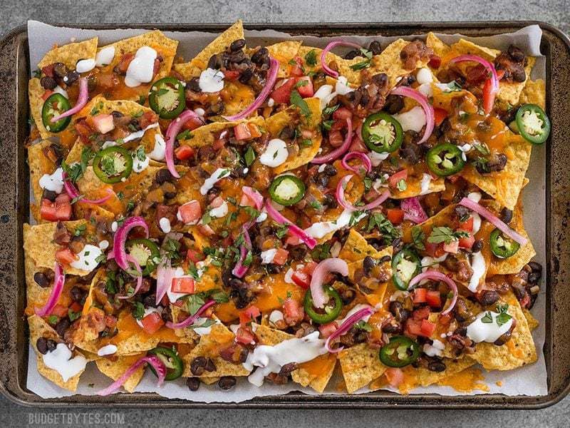 For the perfect Spicy Baked Black Bean Nachos, layer your chips and toppings for the perfect chip-to-topping ratio.