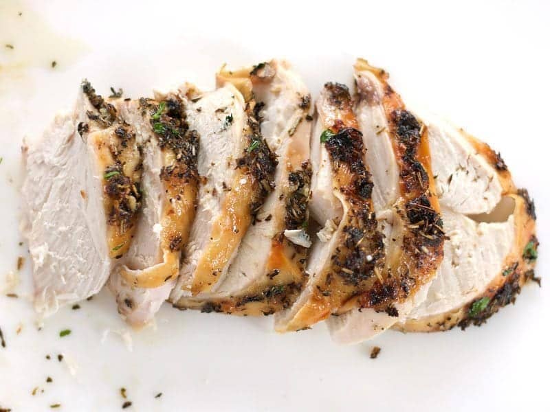 Sliced Herb Roasted Chicken Breast on a cutting board
