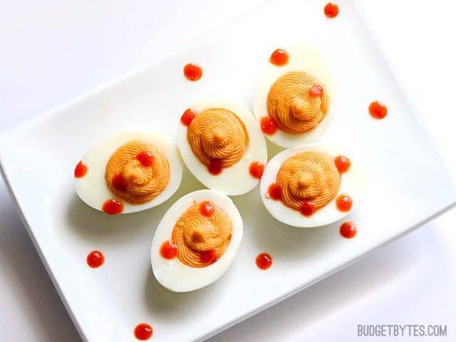 Eggs placed on plate and drizzled with Siracha 