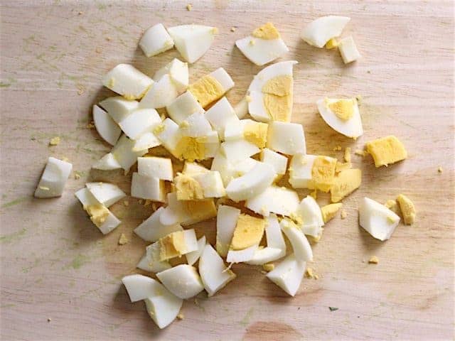 Diced hard boiled eggs on a wooden cutting board
