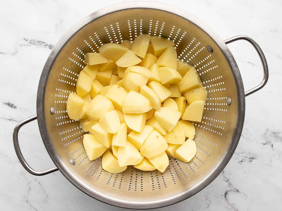 Peeled and diced potatoes in a colander