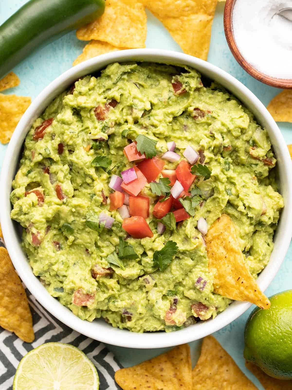 overhead view of a bowl of guacamole surrounded by chips.
