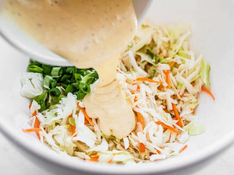 Add coleslaw dressing to cabbage in the bowl