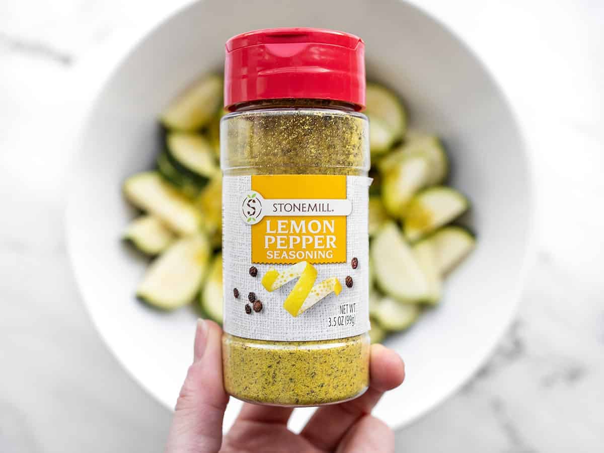 bottle of lemon pepper seasoning with zucchini in the background
