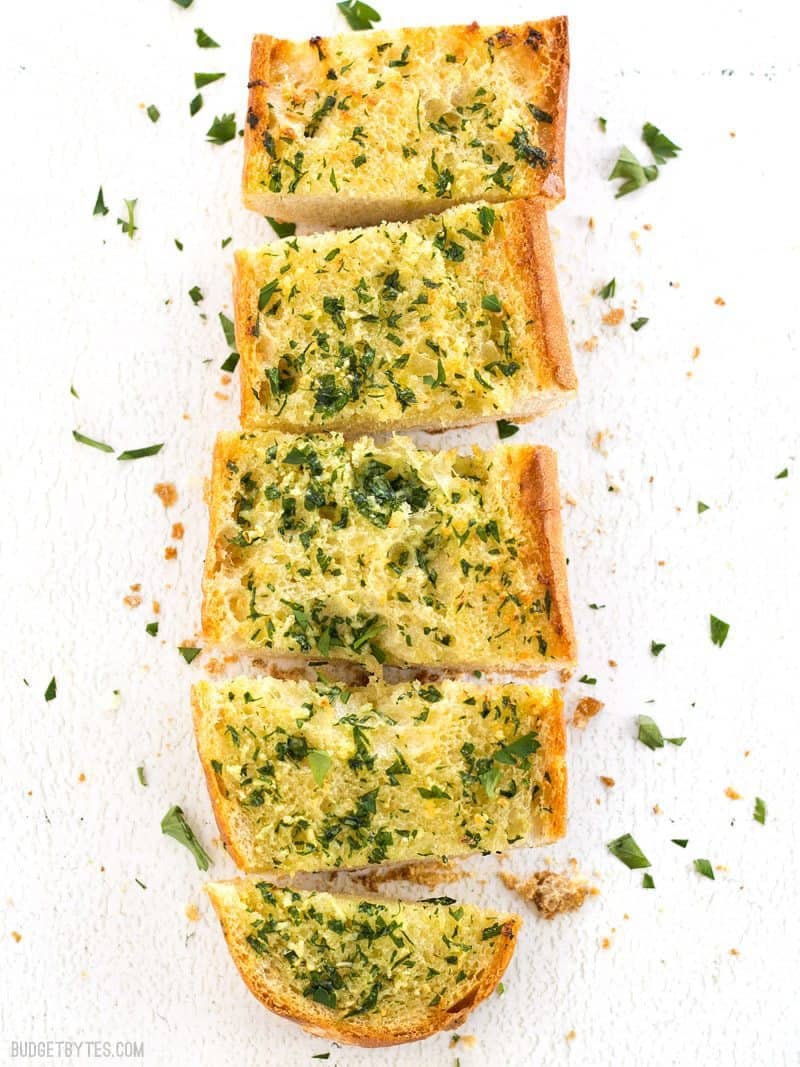 Overhead view of Homemade Garlic Bread cut into pieces and garnished with fresh parsley