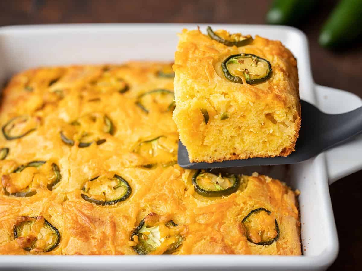 A piece of jalapeño Cornbread being lifted out of the baking dish