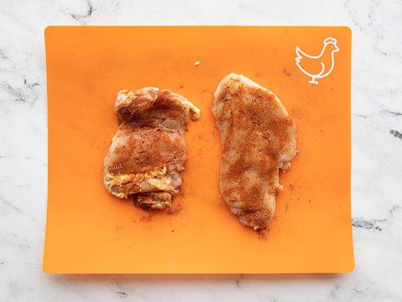 seasoned chicken pieces on a cutting board