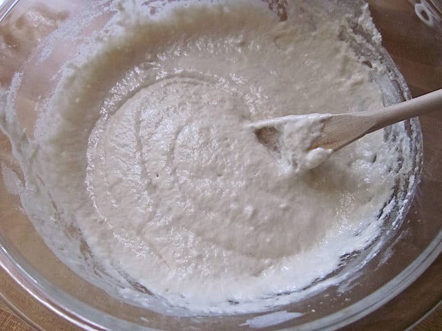 add yeast water to flour and salt in mixing bowl with wooden spoon 