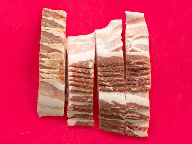 Sliced Bacon on red cutting board 