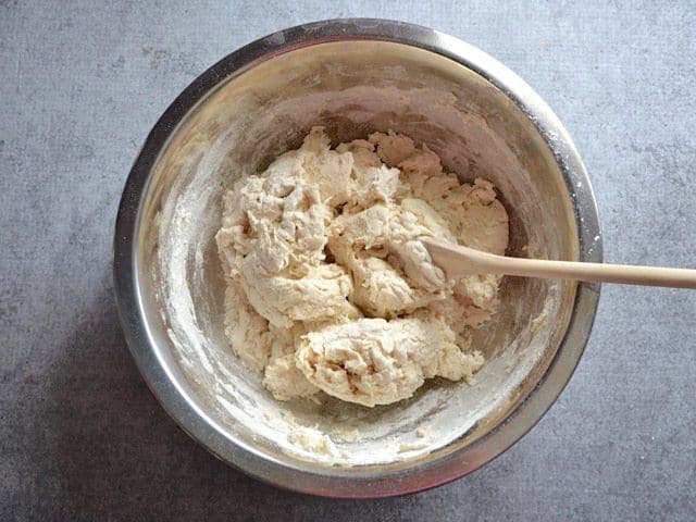 Shaggy Dough ball in mixing bowl with a wooden spoon