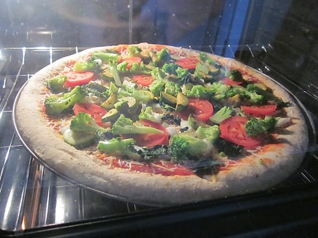 pizza with toppings baking in oven 