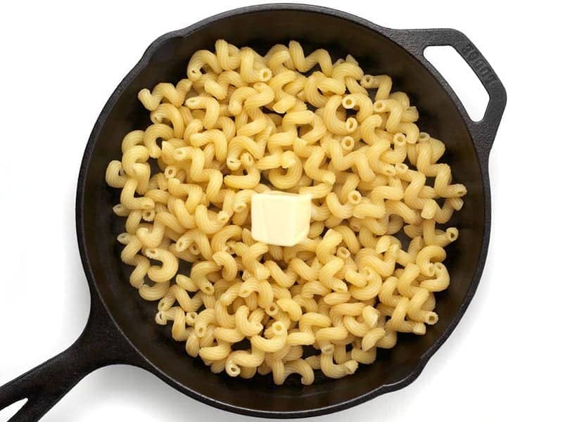 Butter melting into cooked Pasta in the cast iron skillet