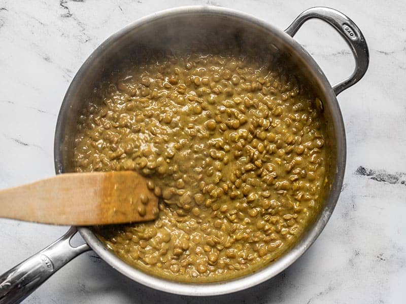 Simmered coconut curry lentils with a wooden spatula