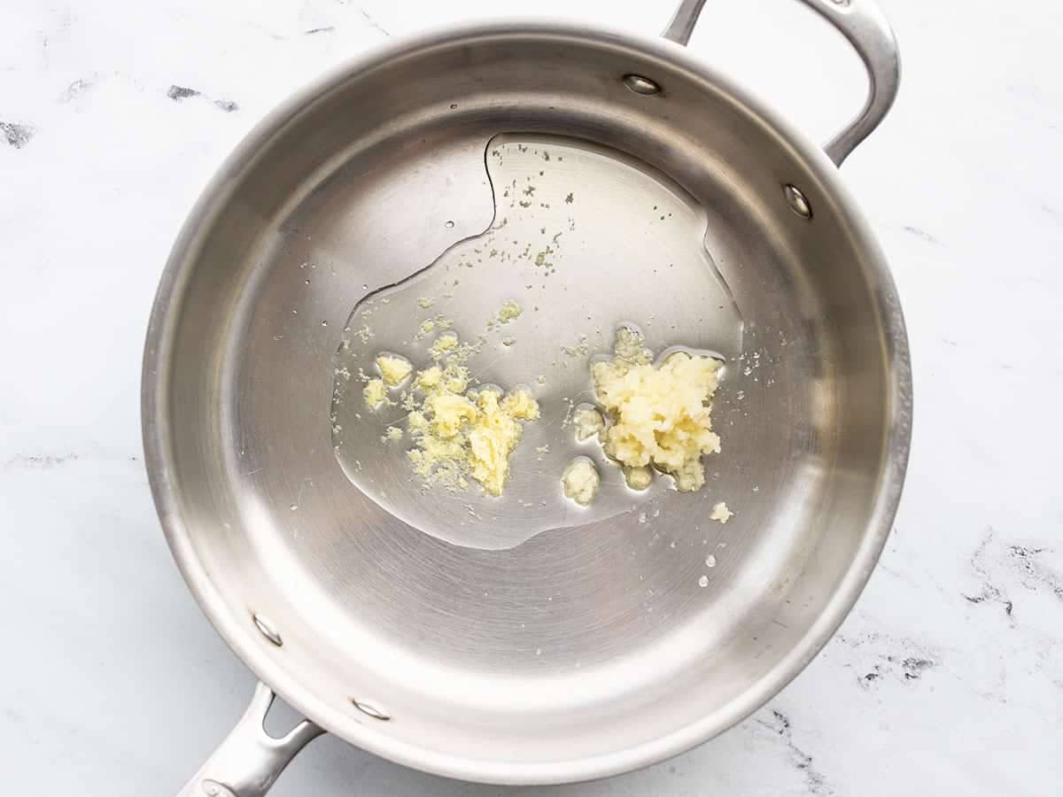 Minced garlic and grated ginger in a skillet with oil