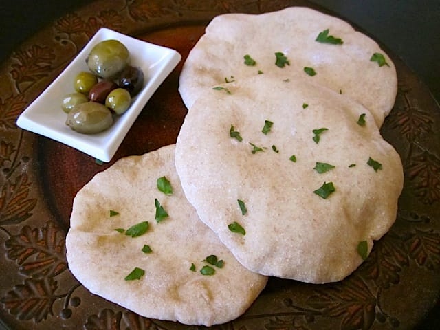 pita bread with little side of olives next to them 