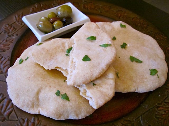 home made wheat pita with small bowl of olives on the side 