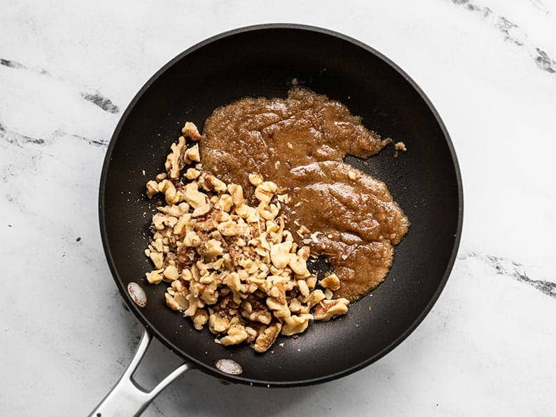 Walnuts added to skillet with molten brown sugar