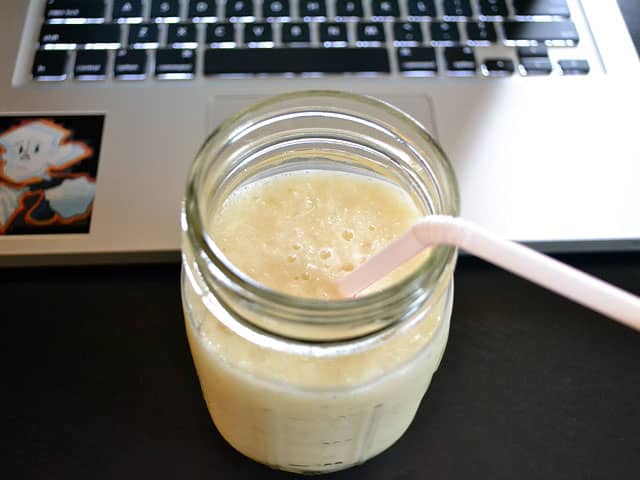 Jar of pineapple ginger lassi with straw 