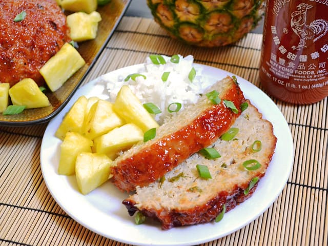 Plate of two slices of Thai Turkey Meatloaf with a side of rice and side of pineapple