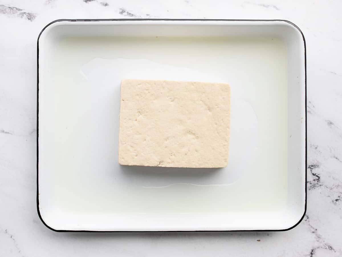 pressed tofu with liquid all around the dish