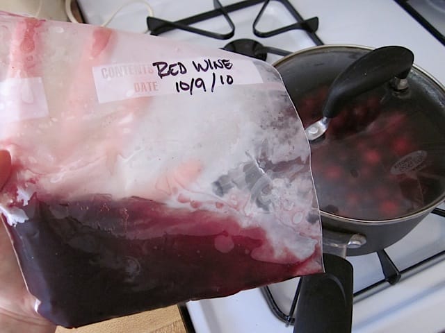 frozen wine being added to mixture in pot 