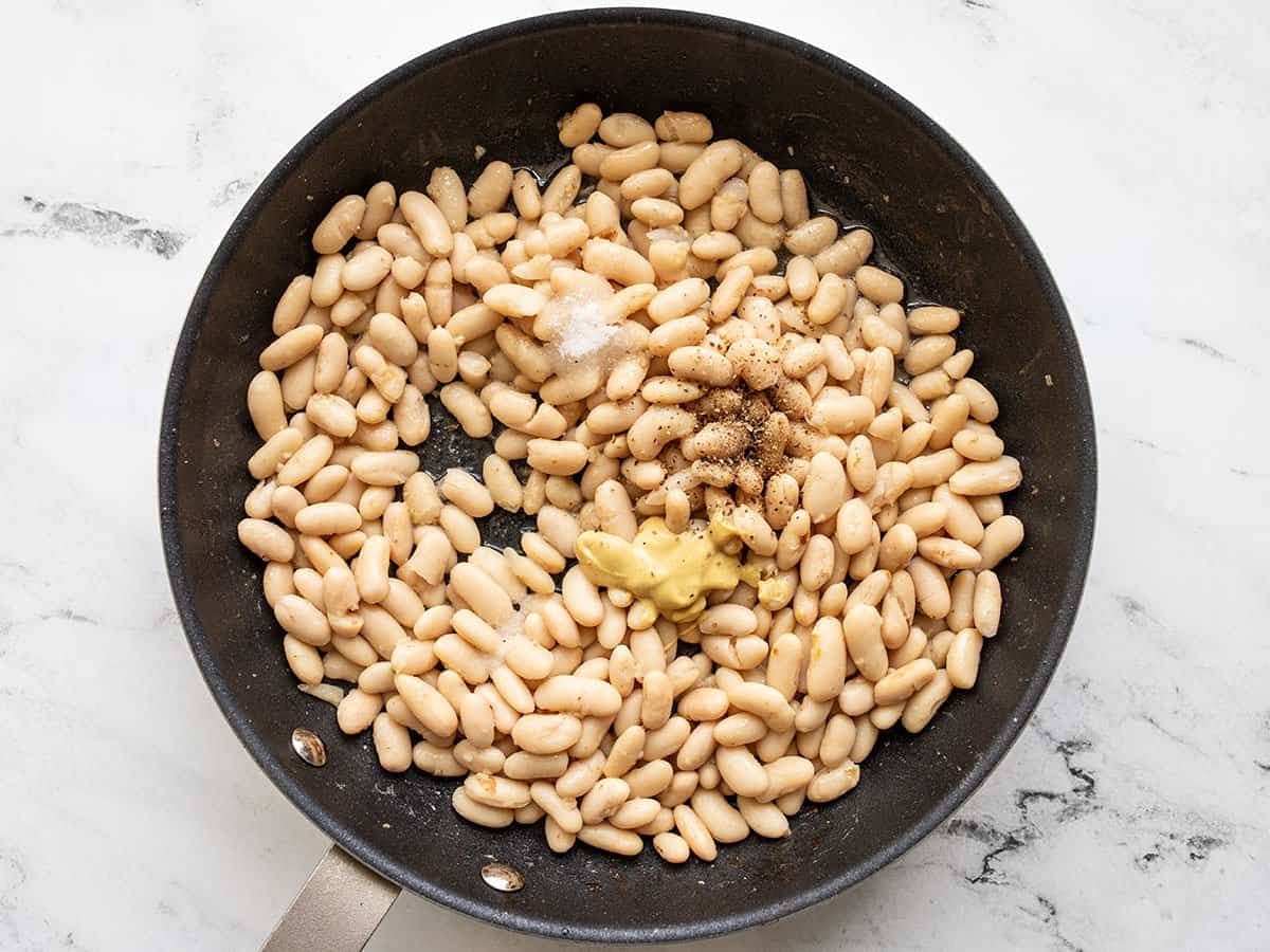 Beans and vinaigrette ingredients added to the skillet.