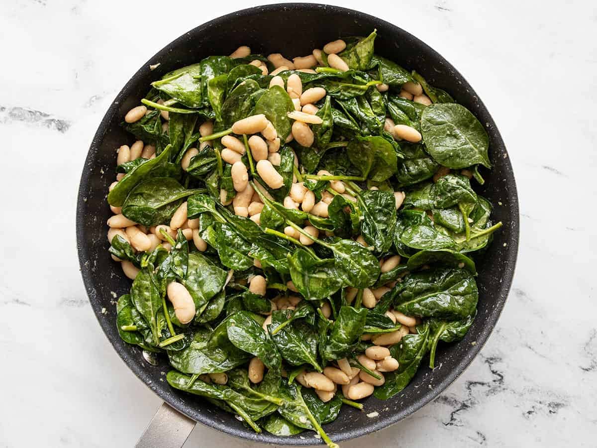 half-wilted spinach mixed into the beans in the skillet.