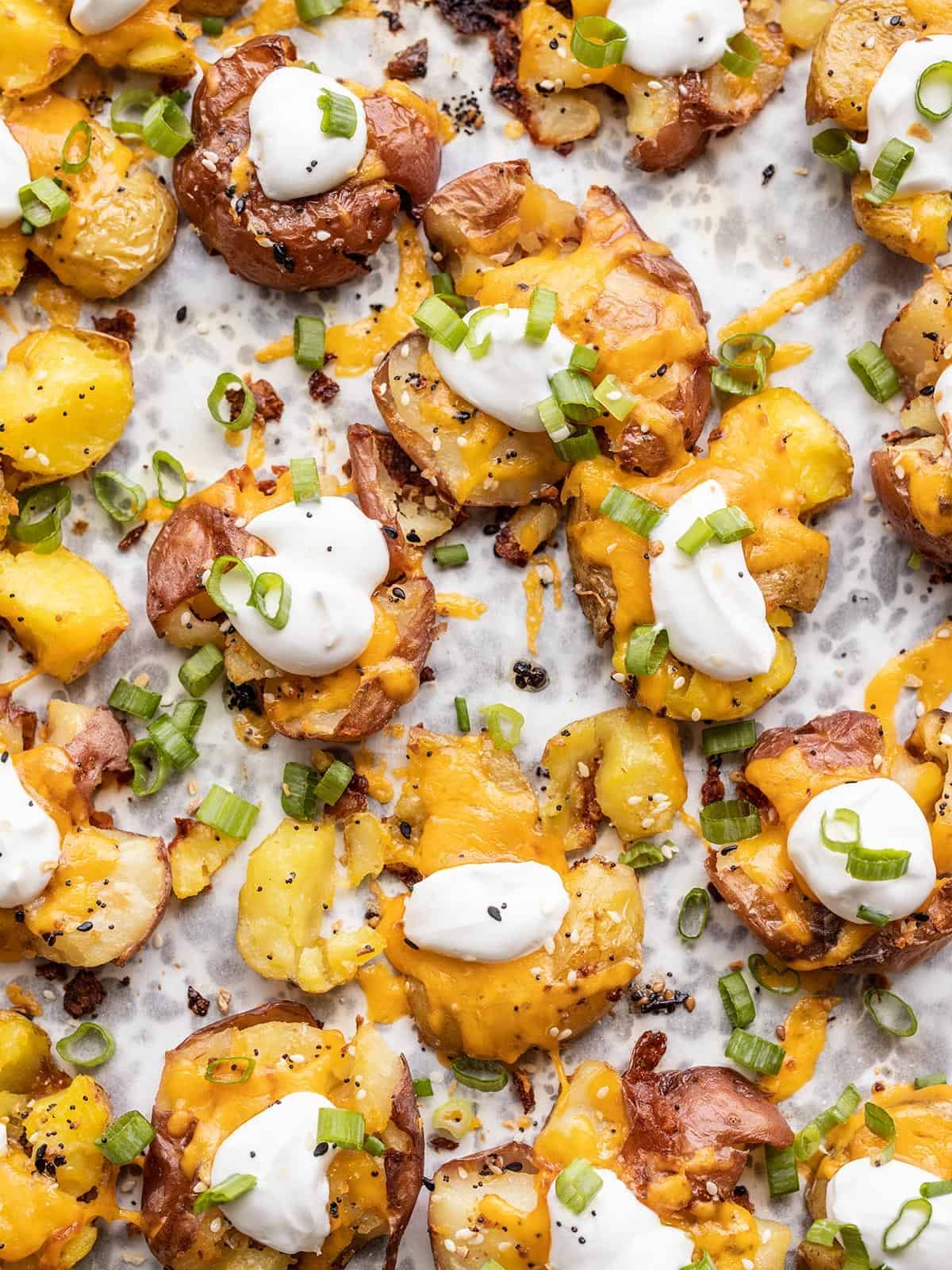 Close up of loaded smashed potatoes on the baking sheet