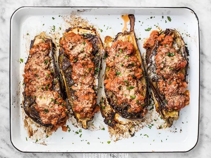 Four Roasted Eggplant with Meat Sauce lined up on a baking sheet