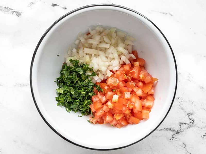 Chopped tomato onion and cilantro in a bowl