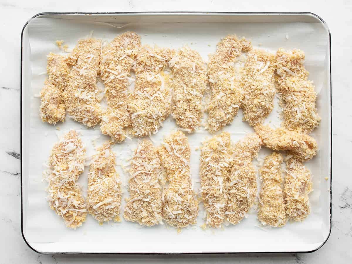 Breaded chicken strips on a baking tray