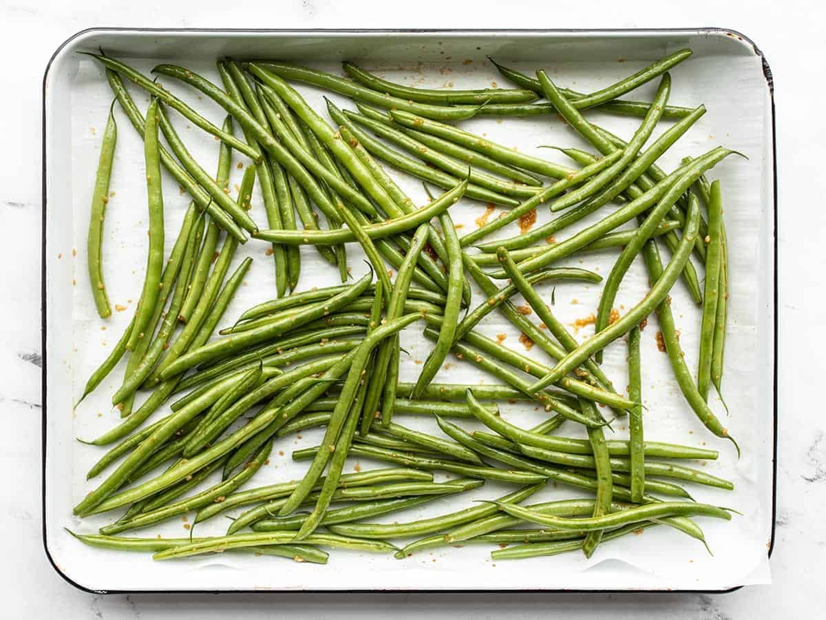 Seasoned green beans on the baking sheet