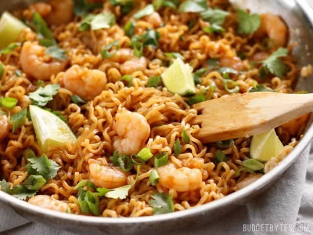 Close up of Lime Shrimp Dragon Noodles in the skillet with a wooden pasta fork