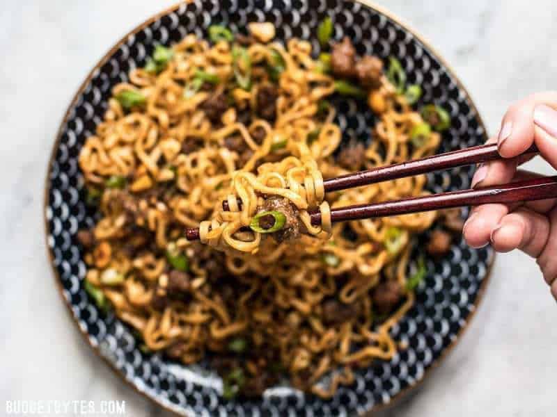 Close up of Pork and Peanut Dragon Noodles on chopsticks